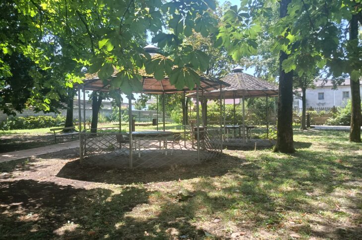Gazebo immersi nel parco alberato con spazi ombreggiati e percorsi pedonali.