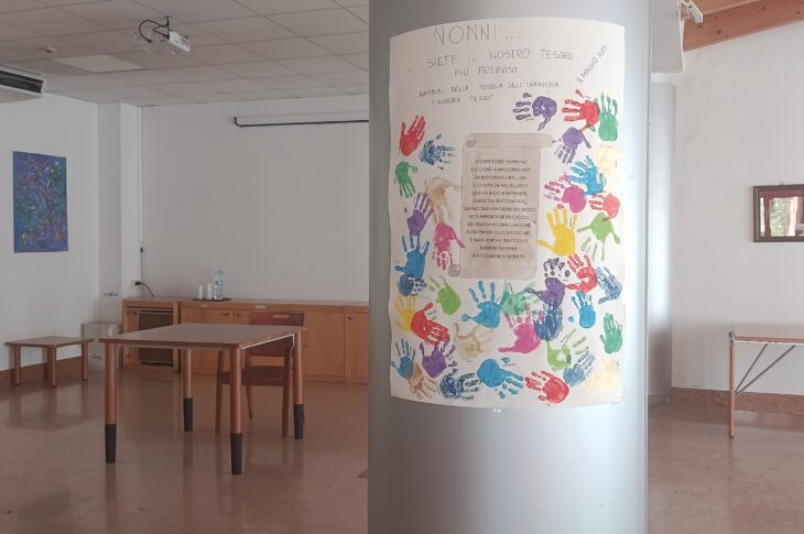 Sala polivalente allestita per attività ricreative con tavoli e spazi multifunzionali.