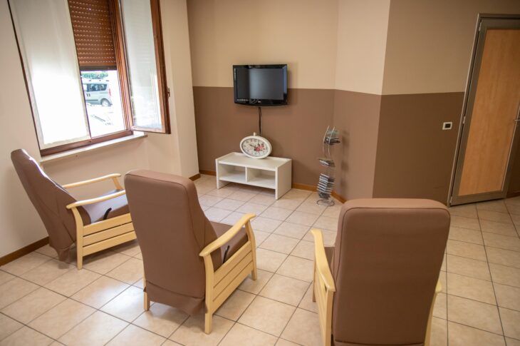 Area relax con poltrone, televisore e posti a sedere.
