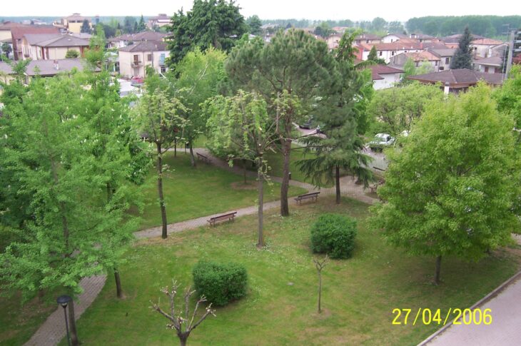Area verde con alberi, prati, panchine e percorsi all'interno del giardino della struttura.