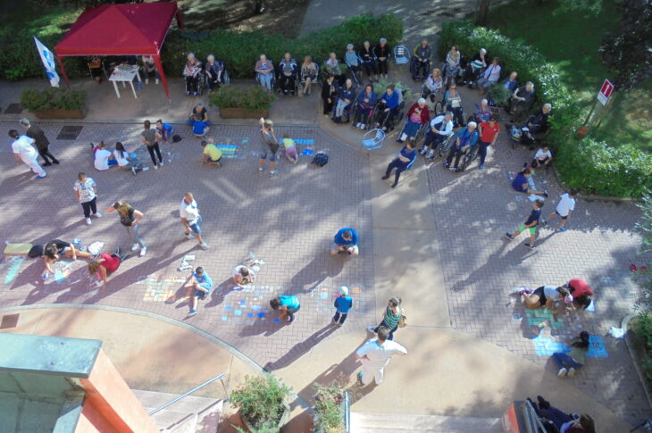 Ospiti e bambini partecipano a un'attività ricreativa all'aperto nel giardino della struttura.